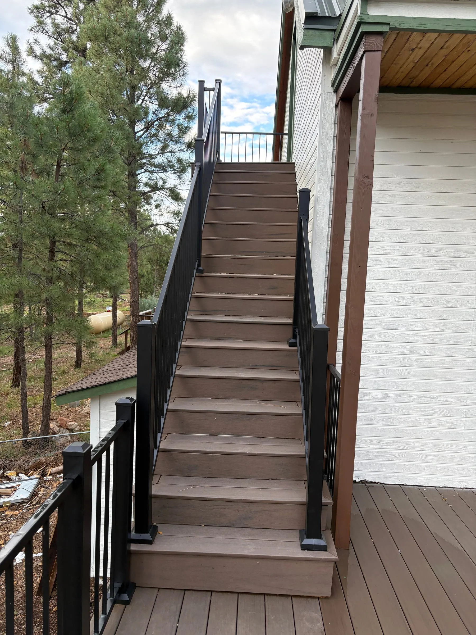 The private staircase up to Nora’s studio, reached from the back deck. It is the only way in, so guests come and go without crossing the lodge.